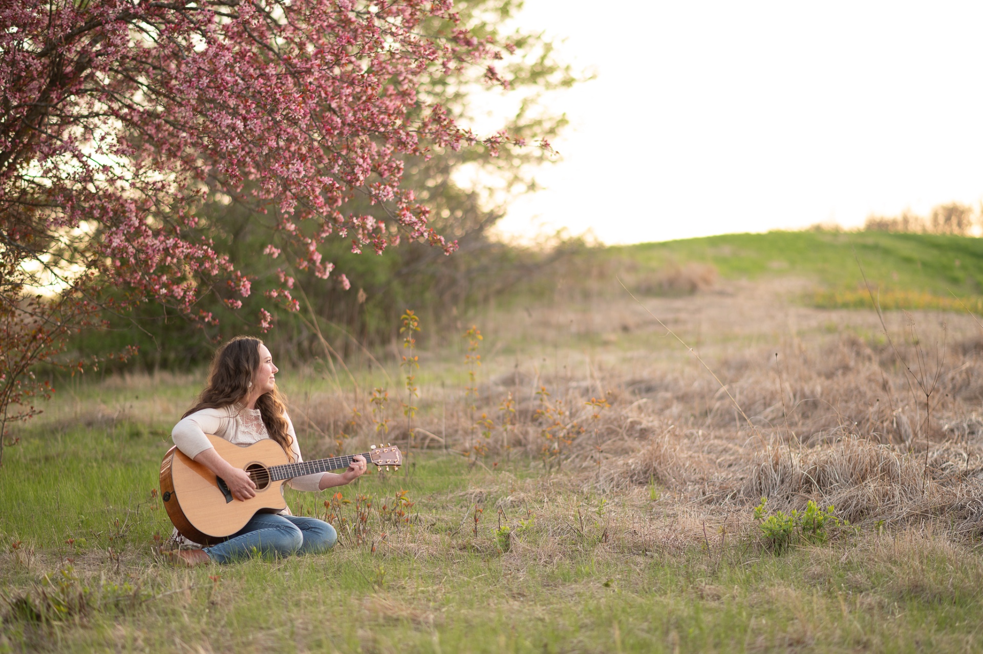Erin Oakley in a field with guitar